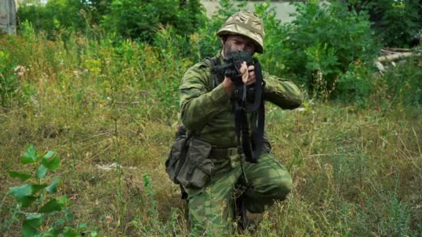 Soldat siktar från en kulspruta medan du sitter i skogen — Stockvideo