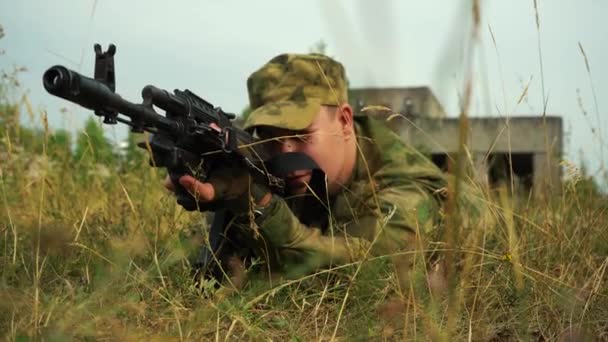 Muž, který míří z kulometu ležícího v křoví. — Stock video