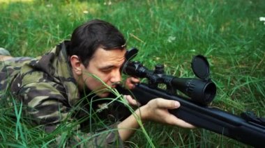 Keskin nişancı çalılıklarda yatarken nişan alır..