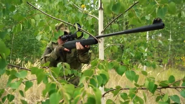 Francotirador apuntando detrás de un árbol — Vídeo de stock