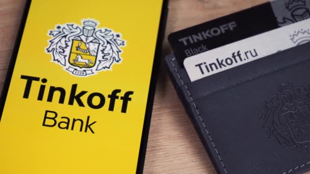 Tinkoff λογότυπο της τράπεζας με πιστωτικές κάρτες στο τραπέζι. Moscow russia 6 Απριλίου 2021 — Αρχείο Βίντεο