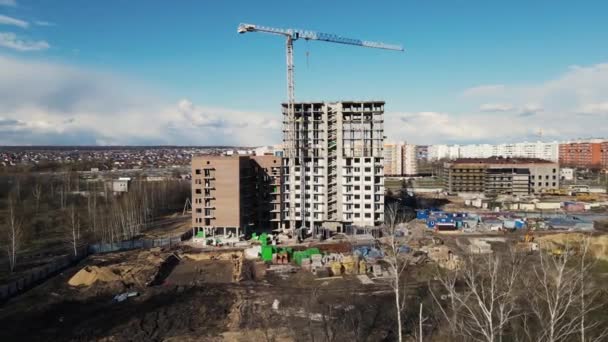 Tiro drone aéreo de um edifício de vários andares em construção usando um guindaste — Vídeo de Stock