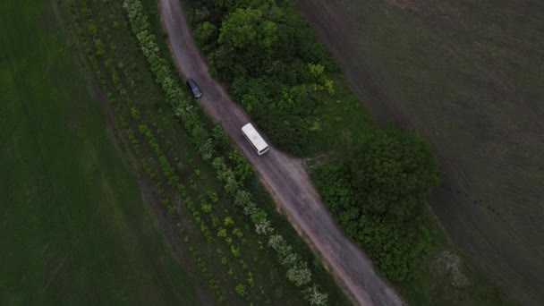 Bus se déplace le long d'un chemin de terre. prise de vue aérienne — Video