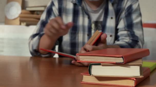 Homem de camisa está lendo um livro enquanto sentado em uma mesa — Vídeo de Stock