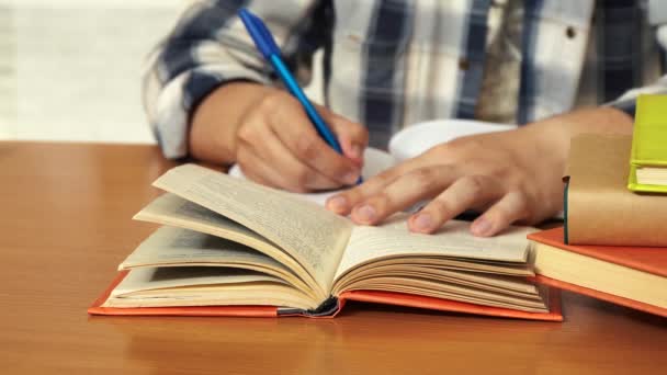 Homme prend des notes dans un carnet tout en étant assis à un bureau — Video