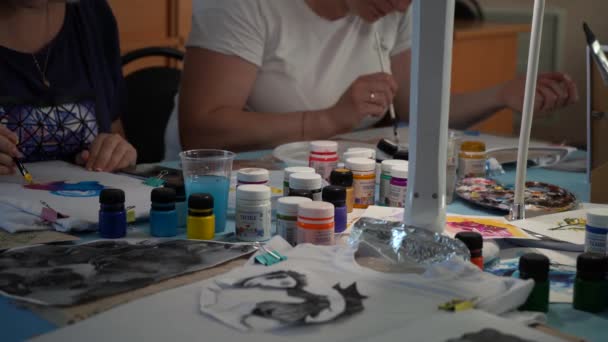 Жінки малюють на аркушах паперу, сидячи за столом у тьмяному світлі. Москва - Росія 20 серпня 2021 року.. — стокове відео