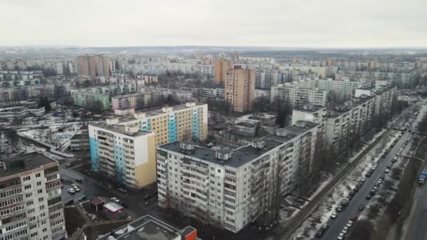 Movimiento de drones a lo largo de una ciudad provincial con edificios de varios pisos en invierno — Vídeos de Stock