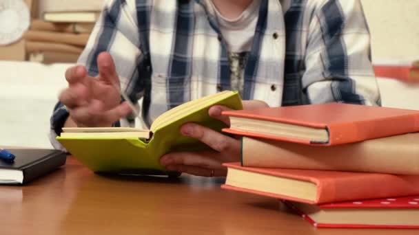 Άνθρωπος που διαβάζει ένα βιβλίο, ενώ κάθεται στη βιβλιοθήκη στο τραπέζι — Αρχείο Βίντεο