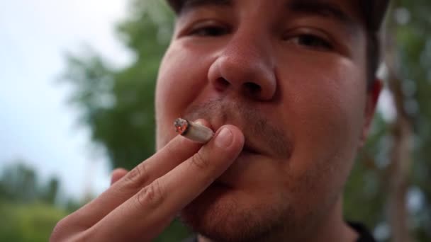 Uomo fuma una sigaretta primo piano mentre in piedi sulla strada. 4k filmati — Video Stock