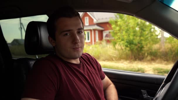 Hombre habla a la cámara mientras está sentado fuera del coche — Vídeos de Stock