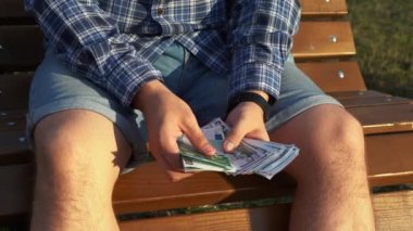 Adam bankta otururken para sayıyor. 4k görüntü