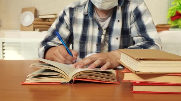 Man antecknar från en bok när man sitter vid ett bord på sitt kontor — Stockvideo