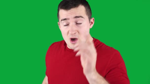 Человек изысканно чихает стоя на зеленом фоне — стоковое видео