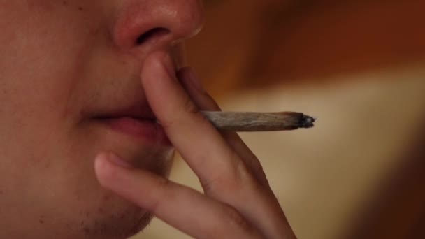 El hombre se arrastra el cigarrillo y exhala humo. cámara lenta — Vídeos de Stock