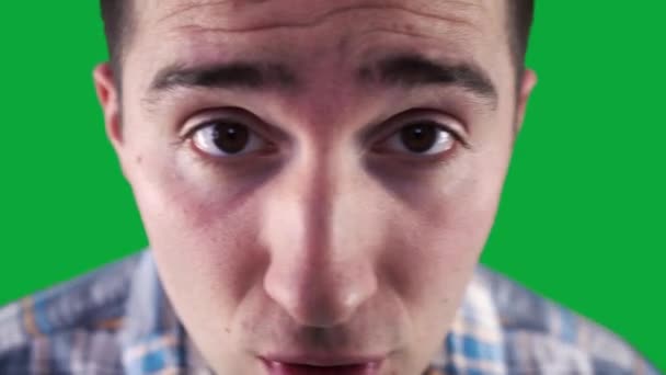 Нахабний хлопець у сорочці смикає на камеру на фоні зеленого екрану — стокове відео