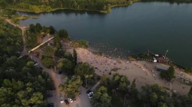 İnsanlarla dolu kumlu bir plajda gölde çekim yapmak.