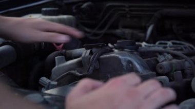 Bir arabanın altında çalışan bir adam.