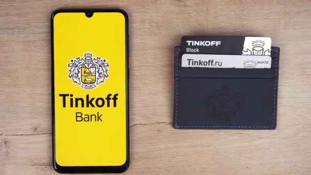 Tinkoff λογότυπο της τράπεζας με πιστωτικές κάρτες στο τραπέζι. Moscow russia 6 Απριλίου 2021 — Αρχείο Βίντεο