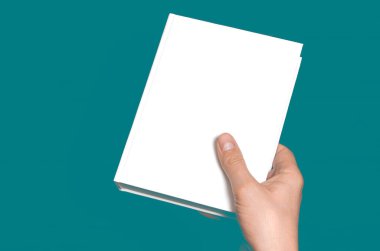 Beyaz kapalı bir kitabın bir maketi. Bir adamın elinde bir metin yeri var.