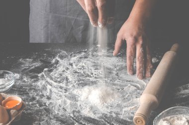 Şef pizza pişirmek için bir iş yeri hazırlıyor.