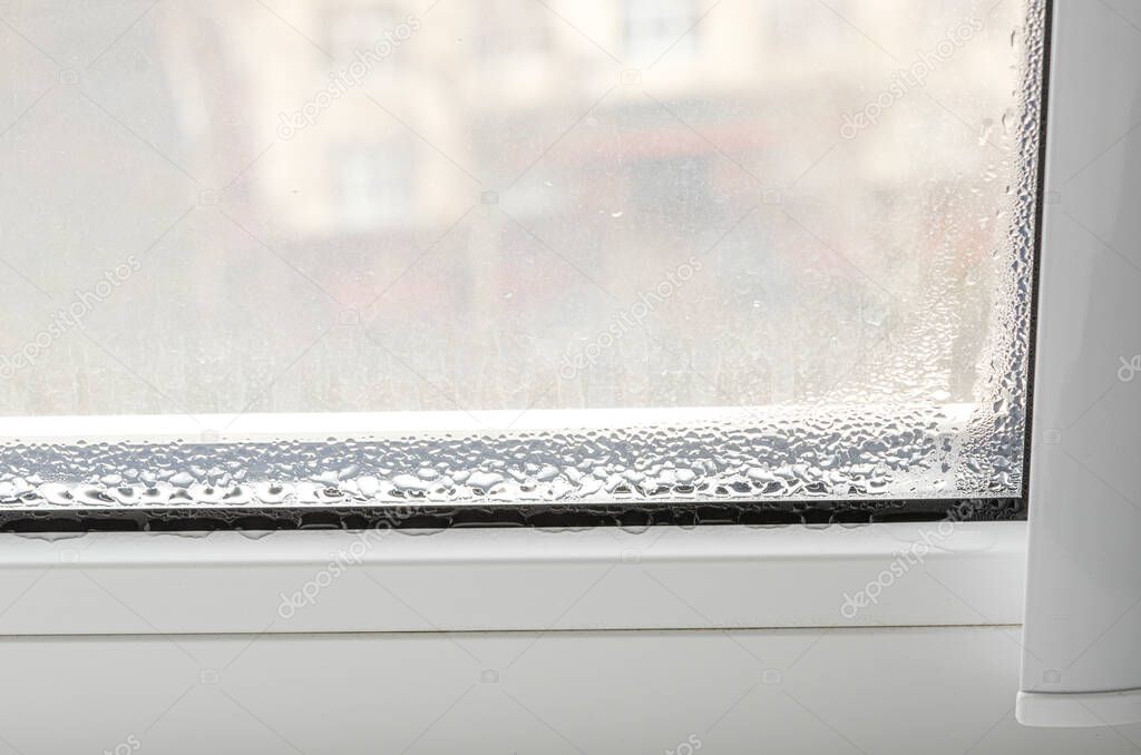 Drops of condensate on a white metal-plastic window. Ecology