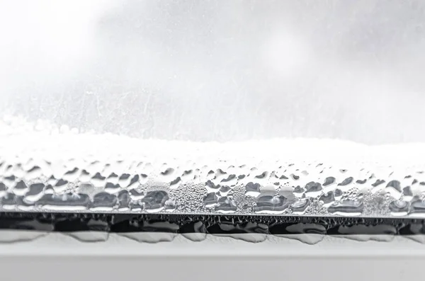 Beyaz plastik bir pencerede siyah küf ve yoğunlaştırılmış damlalar. Yakın plan.