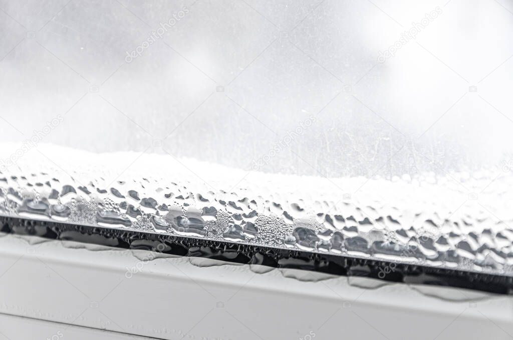 Drops of condensate and black mold on a white plastic window. Close-up