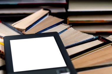 Beyaz ekranlı bir e-kitap ve yazı için bir yer eski kitaplarla dolu bir raftadır.