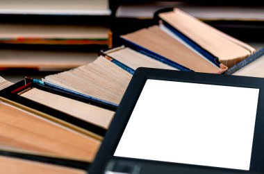 Beyaz ekranlı bir e-kitap ve yazı için bir yer eski kitaplarla dolu bir raftadır.