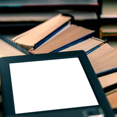 Beyaz ekranlı bir e-kitap ve yazı için bir yer eski kitaplarla dolu bir raftadır.