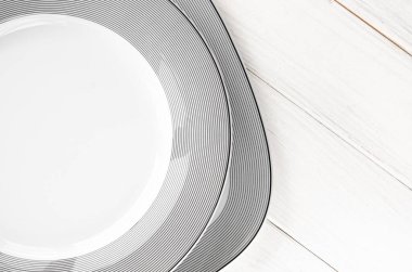 Modern klasik porselen plakalar beyaz ahşap bir masanın üzerinde duruyor.