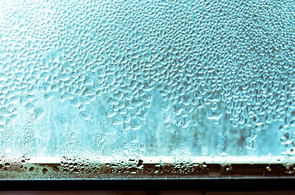 Large drops of condensate on a metal-plastic window. Dew point. Plastic. Ecology