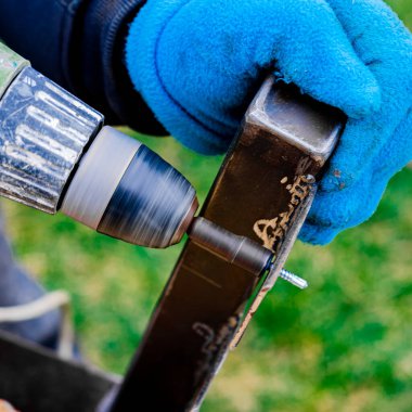 Matkap, tornavida, metal parçalarının iş akışı. Erkek metal işçisi matkap kullanıyor.