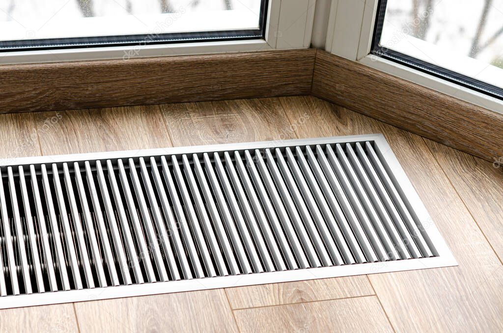 Protective radiator grille built into the floor for heating panoramic windows. Heating grid with ventilation by the floor in hardwood flooring
