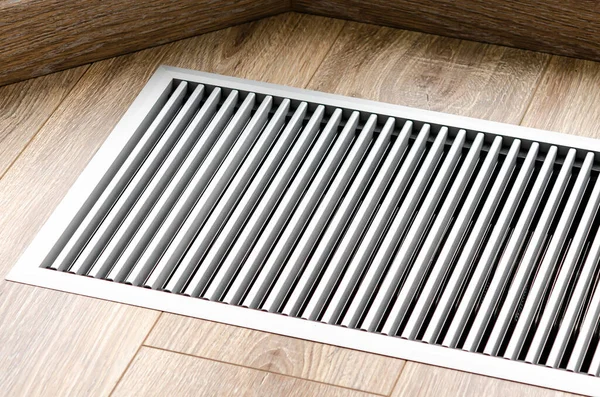 Panoramik pencereleri ısıtmak için yere konmuş koruyucu radyatör ızgarası. Yerdeki ahşap zeminde havalandırmalı ısıtma ızgarası.
