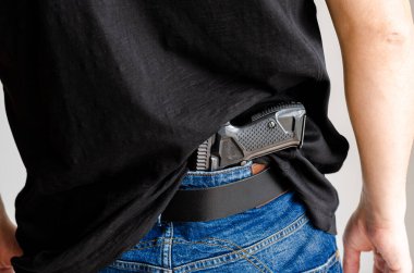 Silahı var. Kot kemerinin altına gizlenmiş tabanca..