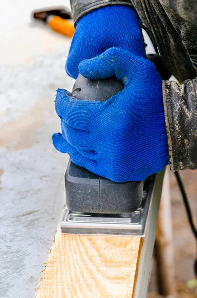 Working with a grind machine. Men\'s hands in blue gloves work with power tools