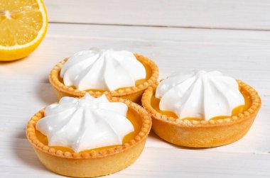 Limonlu pasta. Beyaz zemin üzerinde limon kremalı ve kabarık kremalı küçük limonlu pasta ve kabarık kremalı pasta. Seçici odak.