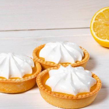 Limonlu pasta. Beyaz zemin üzerinde limon kremalı ve kabarık kremalı küçük limonlu pasta ve kabarık kremalı pasta. Seçici odak.