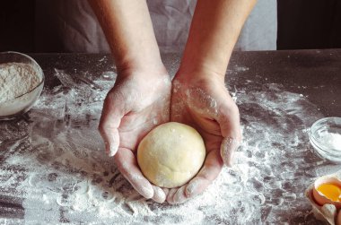 Erkek elleri vişneli turta hazırlamak için hamur yoğurur.