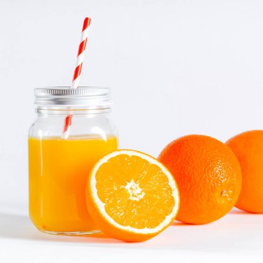 Fast food kapaklı fincanda portakal suyu ve beyaz üzerine izole edilmiş bir dilim portakal suyu. Cam kavanoz ve taze sıkılmış portakal suyu.