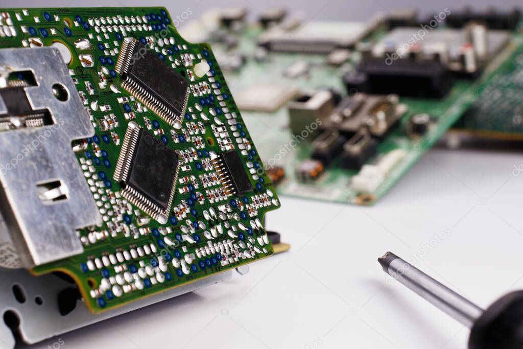 The concept of repairing computers. Composition with selective soft focus from an electric green plateau with microchips and a wrap against other details.