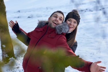 Birbirine aşık genç bir çift, dışarıda kar parkı ormanında kış havasının tadını çıkarıyorlar. Kırmızı ceketli adam siyahlı kadına sarılıyor. Noel ve yeni yıl tatili neşesi. Romantik randevu, ilişki.
