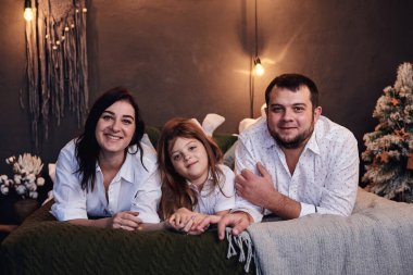 Anneciğim. Baba ve kızı, beyaz gömlekler giyip, sıcak, karanlık bir odada yatağa uzanıyorlar. Noel ve yeni yılı ailenle kutla. Kış tatili eğlence zamanı. Mutlu yıllar ve mutlu Noeller..