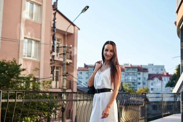 Mulher Morena Jovem Vestindo Vestido Branco Seda Segurando Bolsa Preta — Fotografia de Stock