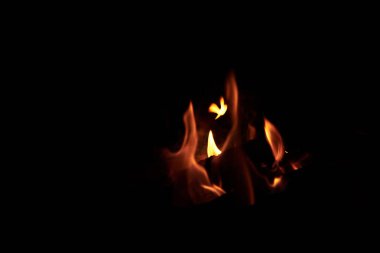 Siyah arka planda parlak turuncu ve sarı alev dilleri. Geceleri şenlik ateşi yakmak. Yazın spor turizmi.