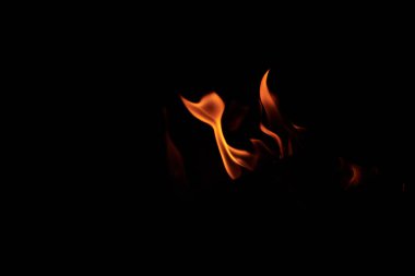 Siyah arka planda parlak turuncu ve sarı alev dilleri. Geceleri şenlik ateşi yakmak. Yazın spor turizmi.