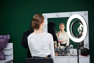 Gelin düğüne hazırlanıyor. Profesyonel makyöz kadın müşterilerin yüzüne makyaj fırçasıyla allık sürüyor. Güzellik stüdyosunda çalışma süreci. Makyaj modelinde yakın plan resim.