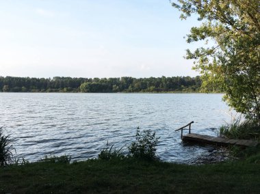 Sonbaharda gölün üzerinde kasvetli, kasvetli bir gökyüzü. Göletli manzara manzarası. Meditasyon için kırsal sakinlik ve rahatlama panoramik görünümü. Kırsal bölgelerdeki uzak yerlere seyahat edilir. Yağmurlu gün.