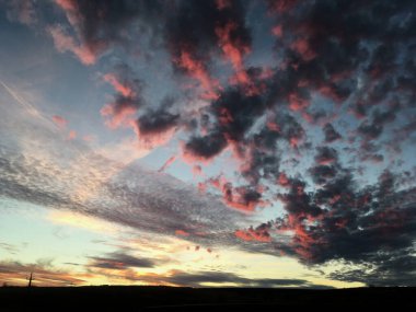 Kırsal alanda gün batımının muhteşem manzarası. Mavi mor gökyüzünde pembe mor bulutlar. Kırsalda sakin bir akşam. Büyülü atmosfer meditasyon ve rahatlama için mükemmeldir..